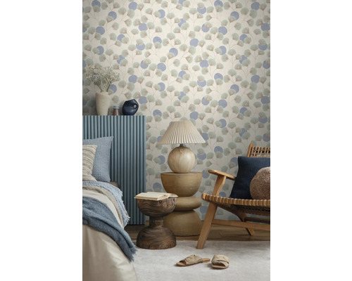 Vliestapete mit Ginkgoblatt-Motiv und Kreisen in einem hellen Zimmer mit Holzmöbeln, Tischlampe und Bett.