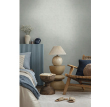 Modernes Schlafzimmer mit strukturierter Tapete, Holzmöbeln, blauen Wandpaneelen, dekorativer Lampe und Textilien in einer hellen Atmosphäre.