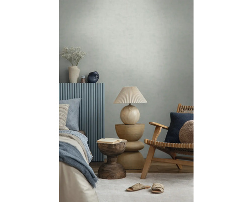 Modernes Schlafzimmer mit strukturierter Tapete, Holzmöbeln, blauen Wandpaneelen, dekorativer Lampe und Textilien in einer hellen Atmosphäre.