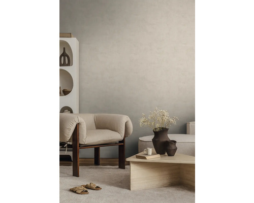 Strukturierte Wandgestaltung in Beige in einem modern eingerichteten Wohnzimmer mit Sessel und Couchtisch.