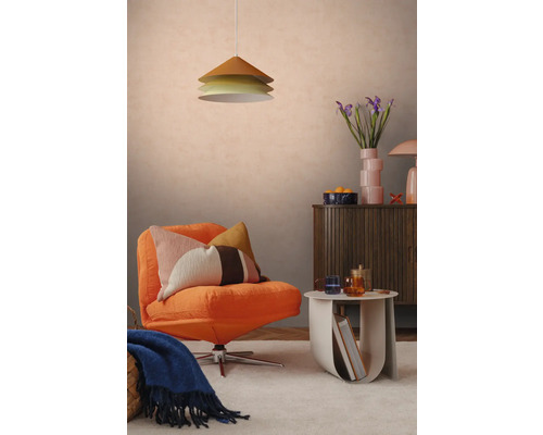 Modern eingerichtetes Wohnzimmer mit orangefarbenem Polstersessel, gemustertem Kissen, dreistufiger Pendelleuchte und Sideboard aus Holz.
