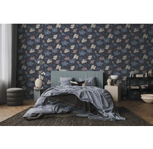 Vliestapete mit floralem Muster in einem modern eingerichteten Schlafzimmer mit grauem Bett und dunklem Teppich.