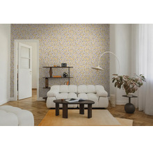 Wohnzimmer mit gelber Blättermuster-Tapete, weißem Polstersofa, dunklem Couchtisch und Fischgrätparkett. Helle und moderne Einrichtung.