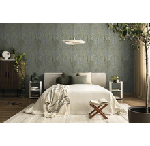 Schlafzimmer mit Vliestapete mit botanischem Blattmuster in Grün und Blau, helles Bett, Holzmöbel und Zimmerpflanzen.