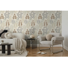 Helle Vliestapete mit botanischem Blättermuster in einem modern eingerichteten Wohnzimmer mit Sofa, Sessel und Parkettboden. Hell und aufgeräumt.
