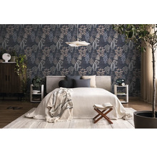 Modern eingerichtetes Schlafzimmer mit dunkler Mustertapete in Blätteroptik, weißem Bett, Holzmöbeln und Zimmerpflanzen.