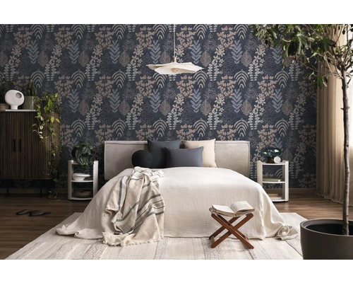 Modern eingerichtetes Schlafzimmer mit dunkler Mustertapete in Blätteroptik, weißem Bett, Holzmöbeln und Zimmerpflanzen.
