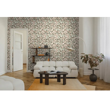 Helles Wohnzimmer mit Vliestapete im Blättermuster, weißem Sofa, dunklem Couchtisch und Fischgrätenparkett.