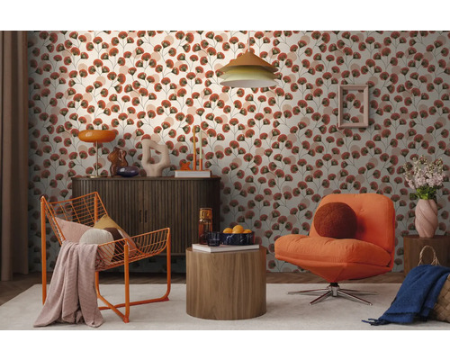 Modernes Wohnzimmer mit floral gemusterter Tapete, einem dunklen Sideboard, einem orangen Drahtsessel und einem Polstersessel auf hellem Teppich.
