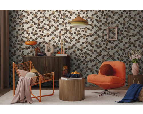 Modernes Zimmer mit floral gemusterter Tapete, orangen Sesseln, einer Holzkommode und dekorativer Beleuchtung.