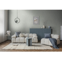 Modernes helles Wohnzimmer mit weißem Modulsofa, blauem Sideboard, grauem Wanddesign, hellem Teppich und rundem Beistelltisch.