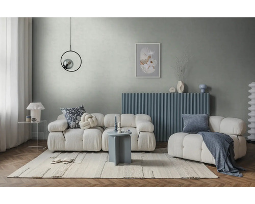 Modernes helles Wohnzimmer mit weißem Modulsofa, blauem Sideboard, grauem Wanddesign, hellem Teppich und rundem Beistelltisch.