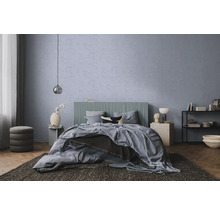Modernes Schlafzimmer mit blau-grauer Strukturwand, Bett mit geripptem Kopfteil, Parkettboden und dunklem Teppich.