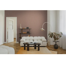 Modernes Wohnzimmer mit weißem Modulsofa, dunklem Couchtisch aus Holz und einer Bogenstehleuchte vor einer altrosa Wand.