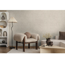 Modernes Wohnzimmer mit hellbeiger Wandfarbe in Betonoptik, hellem Sessel, Stehlampe und weißem Design-Regal auf Holzboden.