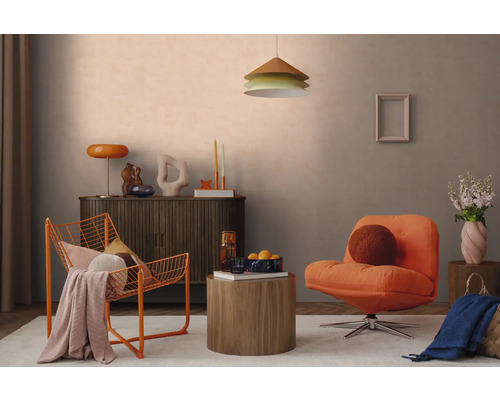 Modern eingerichtetes Wohnzimmer mit orangefarbenem Drahtsessel, Polstersessel, dunklem Sideboard und rundem Holzbeistelltisch vor hellgrauer Wand.
