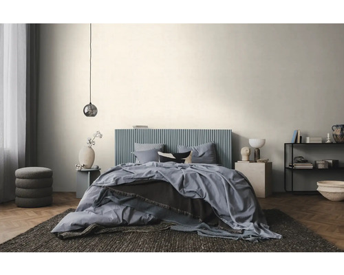 Modernes, helles Schlafzimmer mit einem Bett mit blauem, vertikal geripptem Kopfteil, blauer Bettwäsche und Fischgrätparkett.