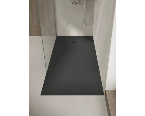 Ebenerdige, rechteckige Duschwanne in Anthrazit mit quadratischem Ablaufdeckel, eingebaut in eine moderne Dusche mit Glaswand.