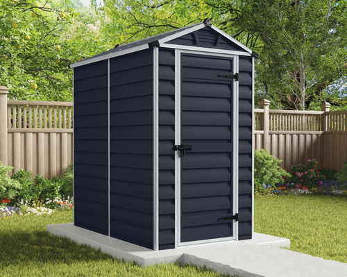 Anthrazitfarbenes Kunststoff-Gerätehaus mit weißem Rahmen und Satteldach auf einem Betonsockel im Garten vor einem Holzzaun.