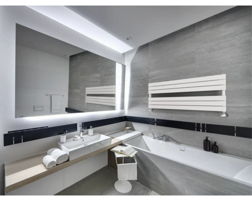 Modernes Badezimmer mit grauen Fliesen, großem beleuchtetem Spiegel, weißem Waschbecken, Badewanne und einem horizontalen Handtuchheizkörper.