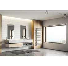 Helles Badezimmer mit Doppelwaschtisch, schwarzen Armaturen, zwei Spiegeln, weißer Fliesenwand, großem Fenster und einem Handtuchheizkörper.