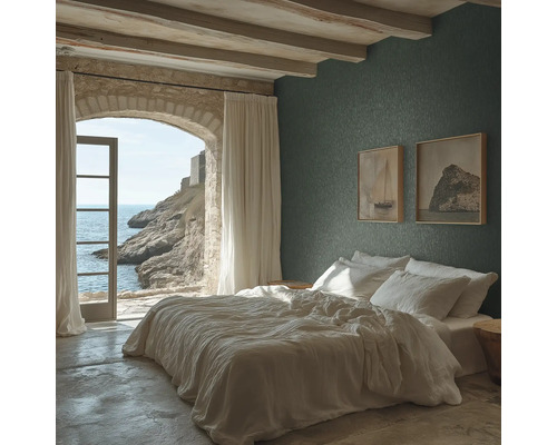 Schlafzimmer mit dunkelgrüner Strukturtapete, weißem Bett, Decke mit Holzbalken und einem Steinbogen mit Blick auf das Meer.