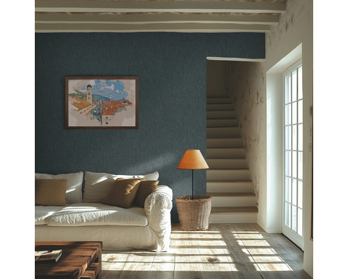 Hell gestaltetes Wohnzimmer mit dunkelblauer Strukturtapete an der Wand, weißem Sofa und sonnigem Lichteinfall auf den Holzboden.