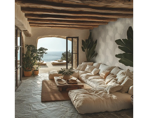 Rustikales Wohnzimmer mit großem Modulsofa, Holzdeckenbalken, Natursteinboden und Meerblick durch eine Rundbogenöffnung.