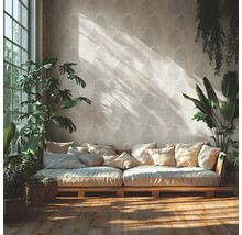 Helles Wohnzimmer mit gemusterter Blatttapete, einem Holzsofa mit vielen Kissen und verschiedenen Zimmerpflanzen auf Holzfußboden.