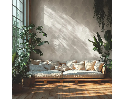 Helles Wohnzimmer mit gemusterter Blatttapete, einem Holzsofa mit vielen Kissen und verschiedenen Zimmerpflanzen auf Holzfußboden.