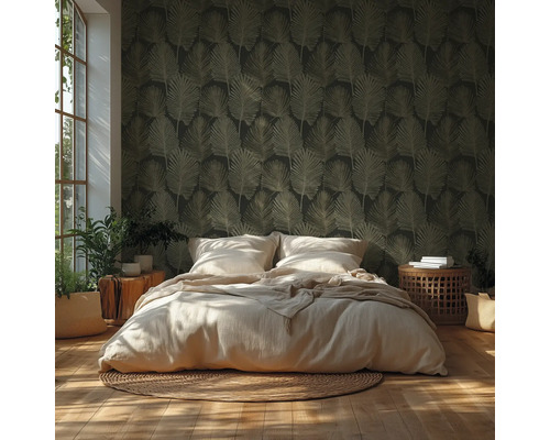 Schlafzimmer mit dunkel gemusterter Tapete mit Blattmotiv, hellem Bett, geflochtenem Teppich, Holzboden und Zimmerpflanzen in hellem Licht.