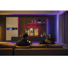 Modernes Wohnzimmer mit smarter LED-Ambientebeleuchtung hinter dem Fernseher und an den Möbeln für eine stimmungsvolle Atmosphäre.