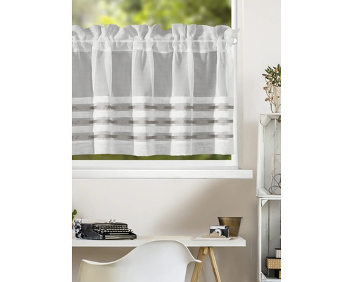 Halbtransparente Scheibengardine aus Stoff mit horizontalen Streifen an einem Fenster über einem organisierten, hellen Arbeitsplatz mit Schreibmaschine.