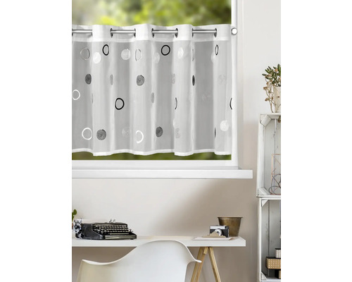 Transparente Bistrogardine mit Ösen und modernem Kreismuster vor einem Fenster in einem hellen, organisierten Arbeitszimmer.