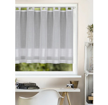 Weiße, halbtransparente Scheibengardine mit Schlaufen und Querstreifen an einem hellen Fenster über einem Schreibtisch mit Schreibmaschine.