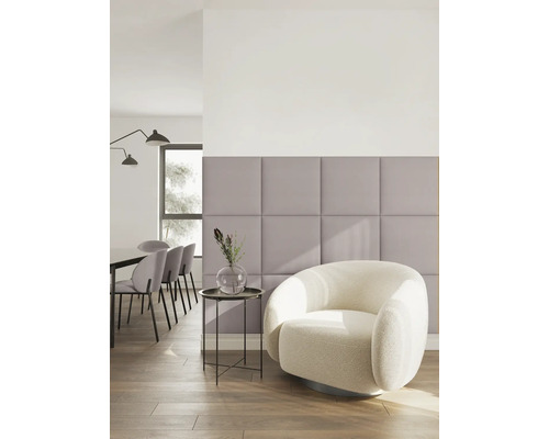 Moderner, heller Wohnbereich mit fliederfarbenen Polster-Wandpaneelen, einem weißen Bouclé-Sessel und einer Essgruppe im Hintergrund.