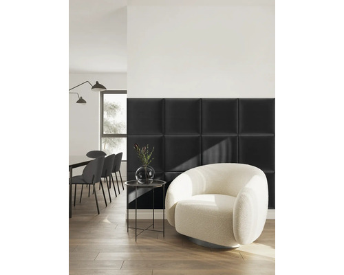 Modernes Zimmer mit schwarzen quadratischen Polsterwandpaneelen, einem weißen runden Sessel und einem Essbereich auf Holzboden.