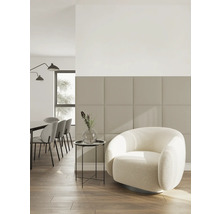 Modernes Wohnzimmer mit quadratischen Wandpaneelen, weißem Sessel und Holzfußboden in hellem, minimalistischem Design.