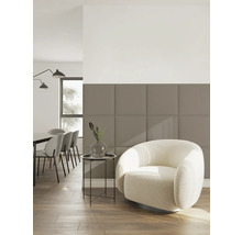 Modernes Wohnzimmer mit einer Wand aus beige-braunen, quadratischen Akustikpaneelen, einem cremefarbenen Sessel und einem Essbereich im Hintergrund.