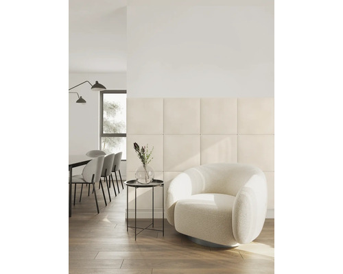 Modernes Wohnzimmer mit quadratischen gepolsterten Wandpaneelen, einem runden Sessel und einem Essbereich in einem hellen, organisierten Raum.