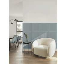 Quadratische gepolsterte Wandpaneele aus Stoff in Blau in einem hellen, modern eingerichteten Wohnzimmer mit weißem Sessel und Holzfußboden.