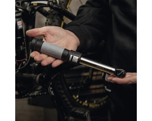 WGB Drehmomentschlüssel für Fahrräder mit einer Skala von 4 bis 20 Newtonmeter, gehalten vor einem Mountainbike.