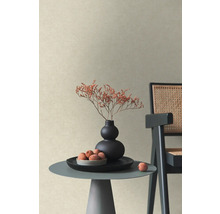 Strukturierte Vliestapete in Beige in einem modernen Wohnraum mit Beistelltisch, Vase mit Trockenblumen und Stuhl.