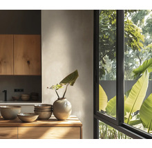 Helle moderne Küche mit Holzschränken, Keramikschalen, einer Vase und einem großen Fenster mit Blick ins Grüne.