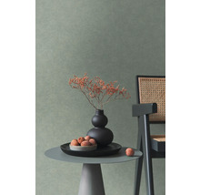 Wand mit strukturierter Tapete in einem modern eingerichteten Raum mit Beistelltisch, Vase und Stuhl mit Geflecht.