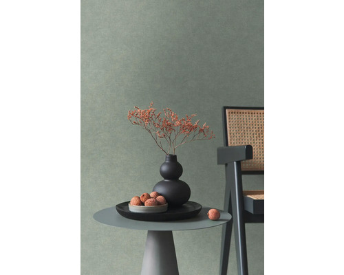 Wand mit strukturierter Tapete in einem modern eingerichteten Raum mit Beistelltisch, Vase und Stuhl mit Geflecht.