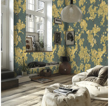 Modernes Wohnzimmer mit Vliestapete mit gelben Blütenmotiven auf dunklem Grund, Holzboden und hellem Sitzsack.