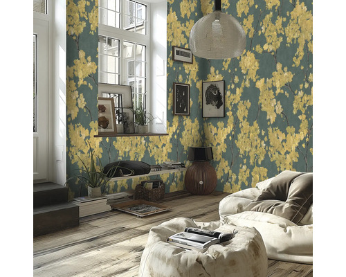 Modernes Wohnzimmer mit Vliestapete mit gelben Blütenmotiven auf dunklem Grund, Holzboden und hellem Sitzsack.