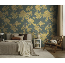 Florale Tapete mit gelben Blumenmustern in einem modern eingerichteten Schlafzimmer mit Bett, Holzstuhl und hellem Teppich.