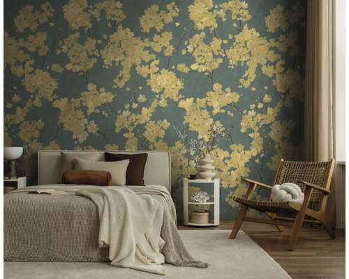 Florale Tapete mit gelben Blumenmustern in einem modern eingerichteten Schlafzimmer mit Bett, Holzstuhl und hellem Teppich.